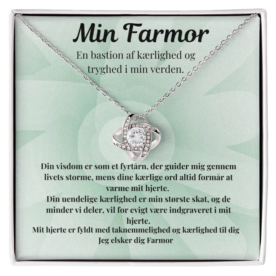 Love Knot-halskæde i rustfrit stål med 14k hvidguldsbelægning og Cubic Zirkonia-sten. Præsenteres i gaveæske med rørende tekst til farmor. En betydningsfuld gaveidé til enhver anledning.