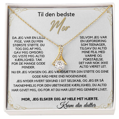 Alluring Beauty halskæde belagt med 18 karat guld i elegant sløjfe-design, med en funklende Cubic Zirkonia-sten. Leveres i gaveæske med rørende Mors Dags-kort – en personlig gave fra datter til mor.