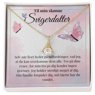 Elegant halskæde med sløjfedesign i 18k guldbelægning og funklende Cubic Zirkonia-sten. Leveres i gaveæske med tekst: "Til min svigerdatter – Jeg holder utroligt meget af dig…". Perfekt gave til eksamen, jubilæum eller særlig anledning.